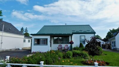 Hy-Grade-Steel-Roofing-System-Metal-Roofing-See-Our-Work-Hunter's-Green-green-yard- white-siding-front-porch