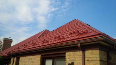 Hy-Grade-Steel-Roofing-System-Metal-Roofing-See-Our-Work-Tile-Red-bungalow-style house-with blue sky with yellow brick siding