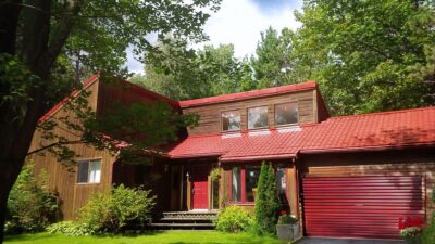 Hy-Grade-Steel-Roofing-System-Metal-Roofing-See-Our-Work-Tile-Red-brown-log-house-with-green-grass-and-blue-sky