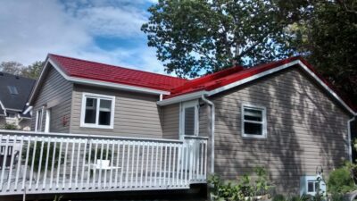 Hy-Grade-Steel-Roofing-System-Metal-Roofing-See-Our-Work-Tile-Red-bungalow-style house-with green grass and blue sky with white siding