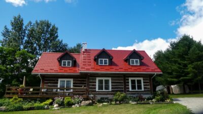 Hy-Grade-Steel-Roofing-System-Metal-Roofing-See-Our-Work-Tile-Red-brown-log-house-with-green-grass-and-blue-sky