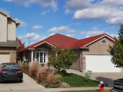 Hy-Grade-Steel-Roofing-System-Metal-Roofing-See-Our-Work-Tile-Red-bungalow-style house-with green grass and blue sky with red or beige brick siding