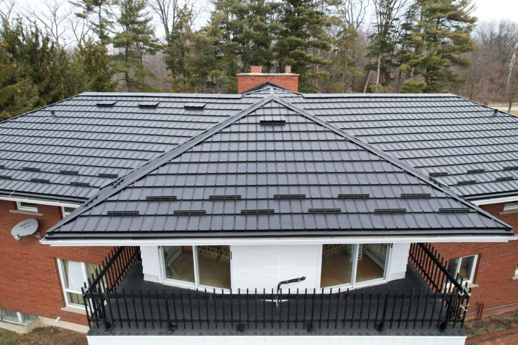 House with a Black Hy-Grade Steel roof on a cloudy day with trees in the background.