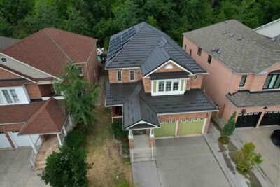 Green garage doors on a 3 story home in Milton with green dark trees behind the home