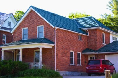 Hy-Grade-Steel-Roofing-System-Metal-Roofing-See-Our-Work-Hunter's-Green-green-yard- red-brick-siding-red-minivan-in-driveway