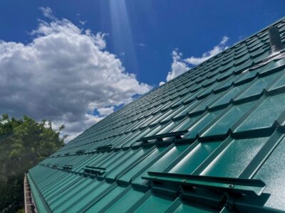 Hy-Grade-Steel-Roofing-System-Metal-Roofing-See-Our-Work-Hunter's-Green-green-on-top-of-roof-blue-sky-background