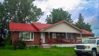 Hy-Grade-Steel-Roofing-System-Metal-Roofing-See-Our-Work-Tile-Red-bungalow-style house-with green grass and-red-brick-and-porch-on-house