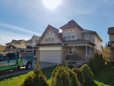 Hy-Grade-Steel-Roofing-System-Metal-Roofing-See-Our-Work-Charcoal-Grey-metal-roof-rural-home-blue-sky-green-grass-in-front-of-home-big-driveway-hy-grade-truck-in-driveway