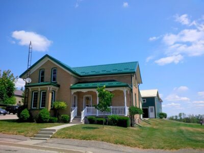 Hy-Grade-Steel-Roofing-System-Metal-Roofing-See-Our-Work-Hunter's-Green-green-yard- yellow-siding-front-porch