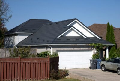Hy-Grade-Steel-Roofing-System-Metal-Roofing-See-Our-Work-Slate-Grey-blue sky behind home - white garage and steel roof