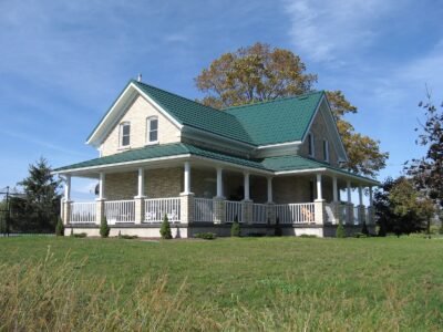 Hy-Grade-Steel-Roofing-System-Metal-Roofing-See-Our-Work-Hunter's-Green-green-yard- white-siding-wrap-around-porch