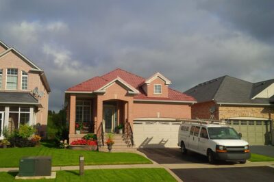 Hy-Grade-Steel-Roofing-System-Metal-Roofing-See-Our-Work-Canners-Brown-metal-roof-pink-siding-Hy-Grade Steel Roofing van in driveway