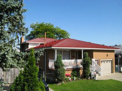 Hy-Grade-Steel-Roofing-System-Metal-Roofing-See-Our-Work-Tile-Red-2-story-log-style house-with green grass and blue sky with yellow siding