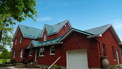Hy-Grade-Steel-Roofing-System-Metal-Roofing-See-Our-Work-Hunter's-Green-blue-sky- red-brick-siding-front-porch
