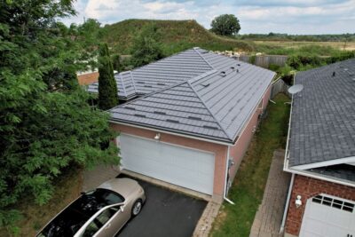 Hy-Grade-Steel-Roofing-System-Metal-Roofing-See-Our-Work-Charcoal-Grey-metal-roof-drone-footage-angle-yellow-and-white-siding