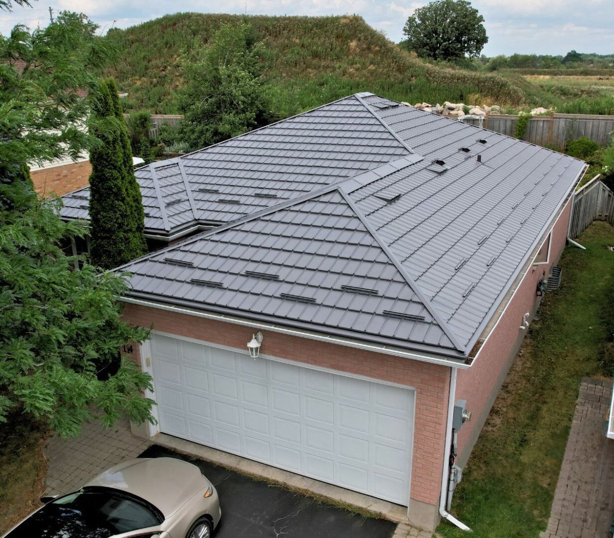 Hy-Grade-Steel-Roofing-System-Metal-Roofing-See-Our-Work-Charcoal-Grey-metal-roof-drone-footage-angle-yellow-and-white-siding