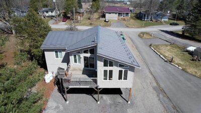 Hy-Grade-Steel-Roofing-System-Metal-Roofing-See-Our-Work-Charcoal-Grey-metal-roof-2-stories-drone-angle-house-on-stilts