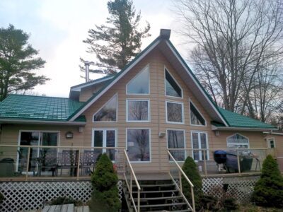 Hy-Grade-Steel-Roofing-System-Metal-Roofing-See-Our-Work-Hunter's-Green-green-yard- yellow-siding-back-porch-windows