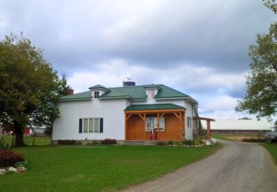 Hy-Grade-Steel-Roofing-System-Metal-Roofing-See-Our-Work-Hunter's-Green-green-yard-country-home-rural-white-siding-wood-front-porch