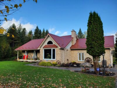 Hy-Grade-Steel-Roofing-System-Metal-Roofing-See-Our-Work-Tile-Red-bungalow-style house-with green grass and blue sky with yellow brick siding